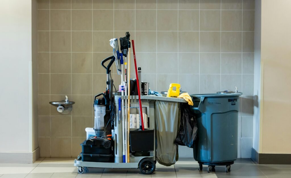 A comprehensive collection of professional cleaning tools on a cart in an indoor environment.